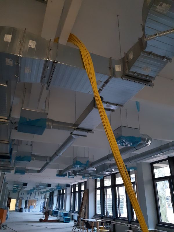 Bild vom E-Prüfungsraum mit von der Decke hängenden Netzwerkstrippen.